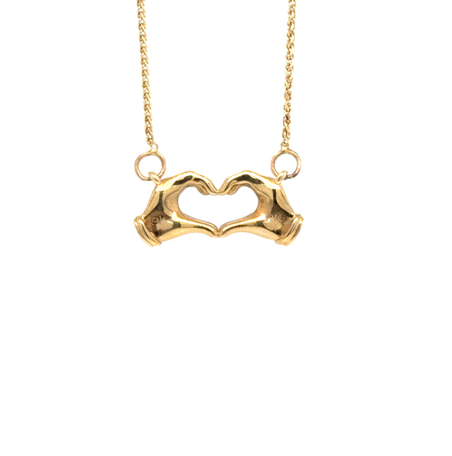 14K gold heart hands necklace on white background – delicate gold chain with hands forming a heart pendant.