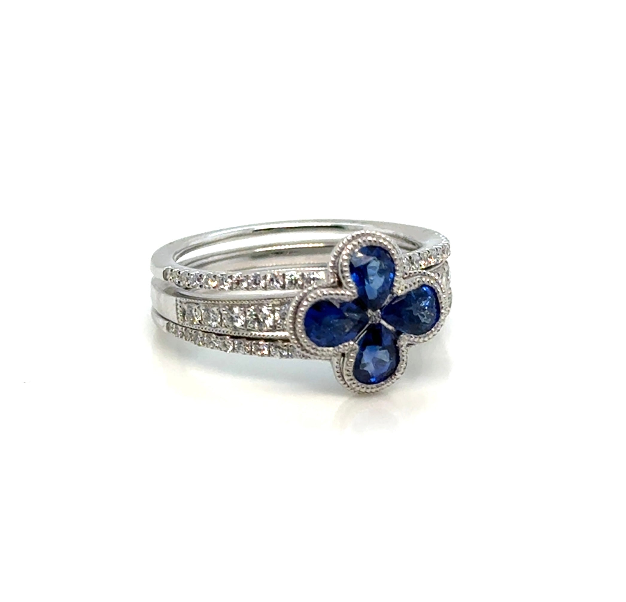 Diamond and sapphire 14K gold floral ring on white background – elegant fine jewelry featuring blue sapphires and sparkling diamonds arranged in a flower-inspired design.