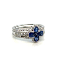 Diamond and sapphire 14K gold floral ring on white background – elegant fine jewelry featuring blue sapphires and sparkling diamonds arranged in a flower-inspired design.