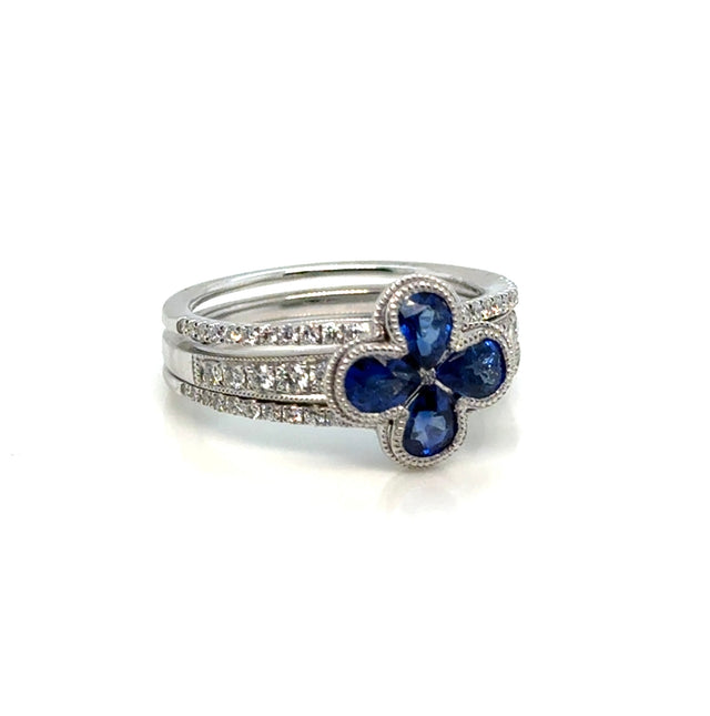 Diamond and sapphire 14K gold floral ring on white background – elegant fine jewelry featuring blue sapphires and sparkling diamonds arranged in a flower-inspired design.