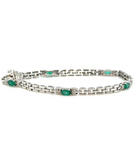 Emerald and diamond 14K white gold bracelet on white background – elegant fine jewelry with vivid green emeralds and sparkling diamonds set in white gold.