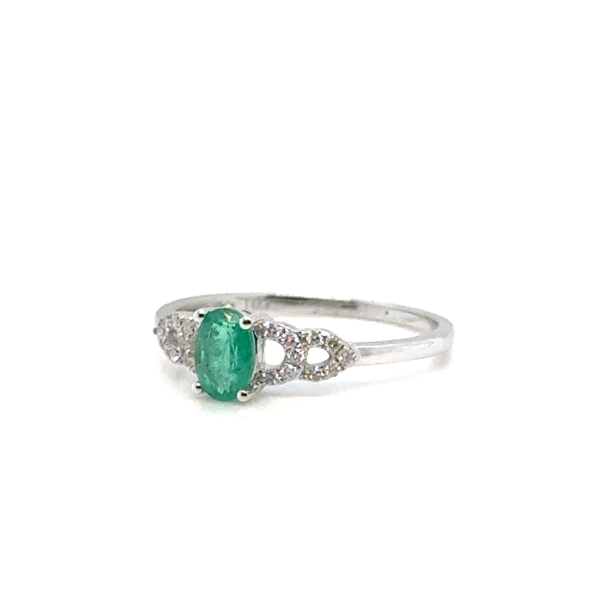 Emerald and diamond 14K gold ring on white background – fine jewelry featuring a vibrant green emerald center stone with sparkling diamond accents in a yellow gold setting.