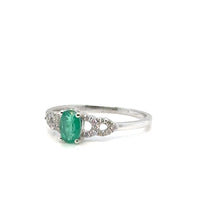 Emerald and diamond 14K gold ring on white background – fine jewelry featuring a vibrant green emerald center stone with sparkling diamond accents in a yellow gold setting.