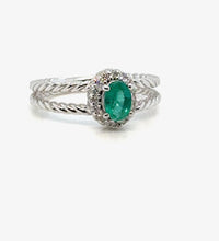 Emerald halo ring in 14K gold on white background – fine jewelry featuring a vibrant green emerald surrounded by a halo of sparkling diamonds in a yellow gold setting.