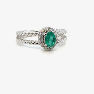 Emerald halo ring in 14K gold on white background – fine jewelry featuring a vibrant green emerald surrounded by a halo of sparkling diamonds in a yellow gold setting.
