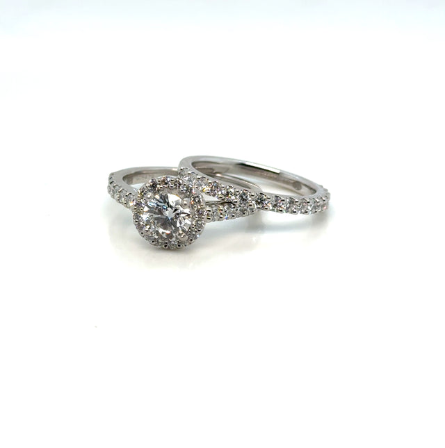 Platinum diamond halo wedding set on white background – elegant bridal jewelry featuring a halo-style engagement ring and a matching diamond wedding band crafted in polished platinum.