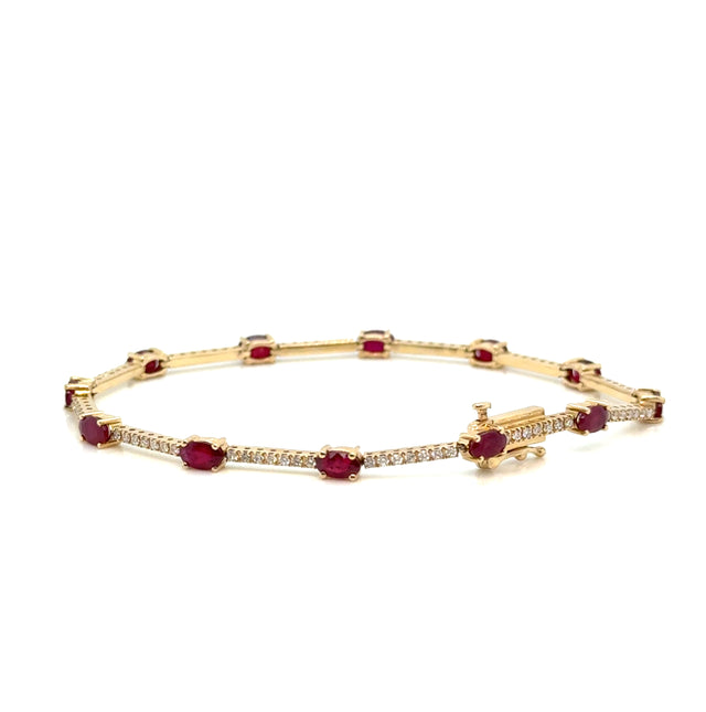 Ruby and diamond 14K gold bracelet on white background – elegant fine jewelry with alternating red rubies and sparkling diamonds set in yellow gold.