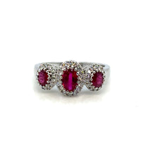 Ruby and diamond halo ring on white background – fine jewelry featuring a vivid red ruby center stone encircled by a halo of sparkling diamonds in a 14K gold setting.