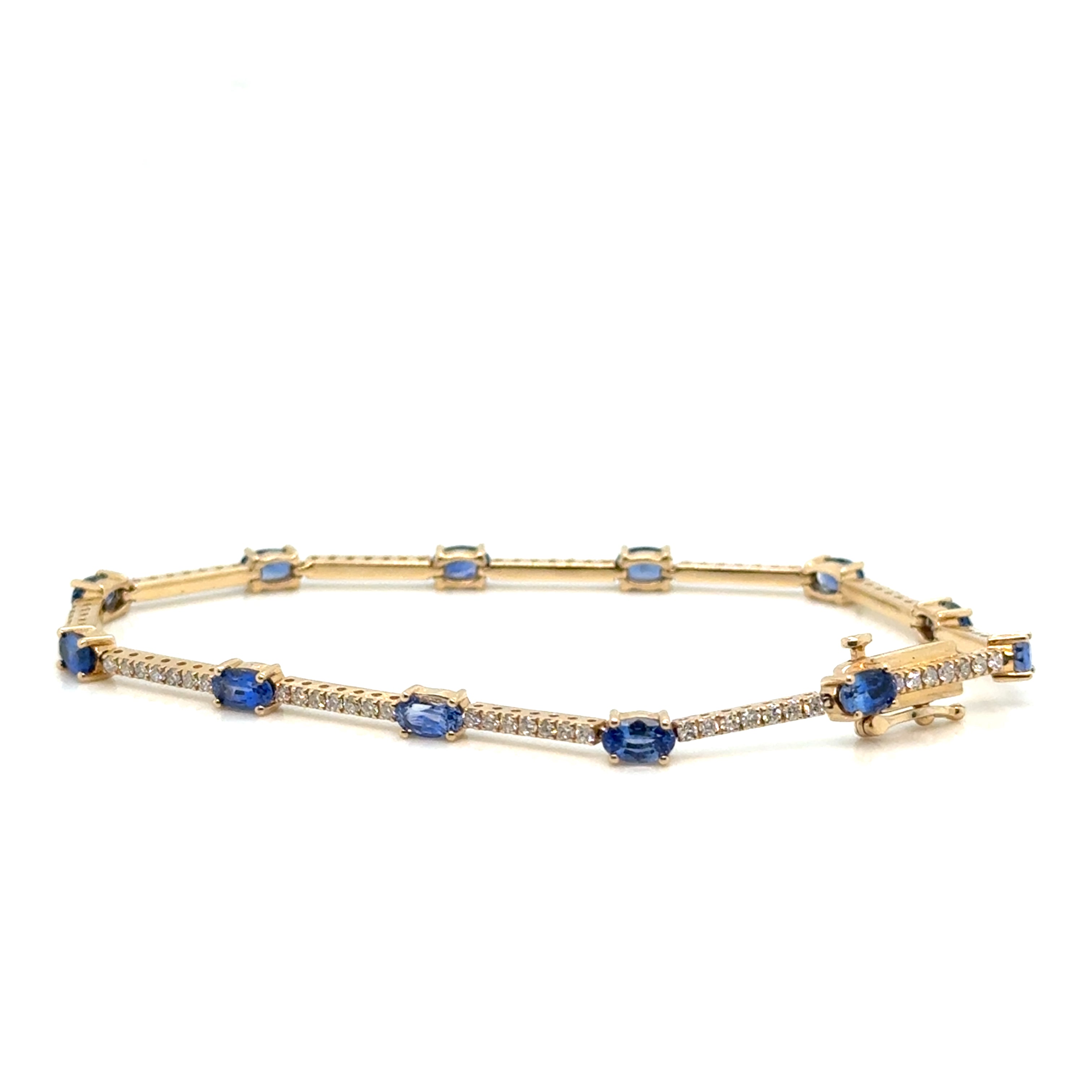 Sapphire and diamond 14K gold bracelet on white background – fine jewelry featuring deep blue sapphires and brilliant diamonds set in yellow gold.